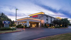 Modernilla designilla varustettu Hampton Inn by Hilton -hotelli, jossa on viihtyisä sisäänkäynti ja hyvin hoidettu ajotie.