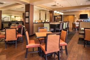 A hotel lobby with multiple seating areas, a reception desk, and a bar. - Hampton Inn San Antonio Stone Oak (San Antonio)
