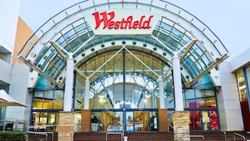 Un centro comercial Westfield con una amplia entrada de vidrio y un letrero grande de Westfield.
