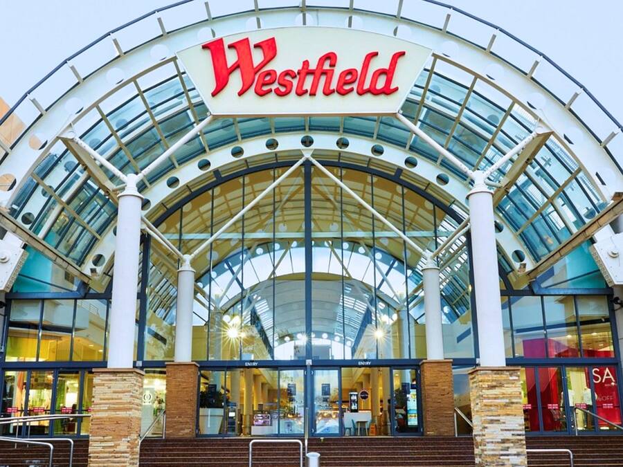 Un centro comercial Westfield con una amplia entrada de vidrio y un letrero grande de Westfield.