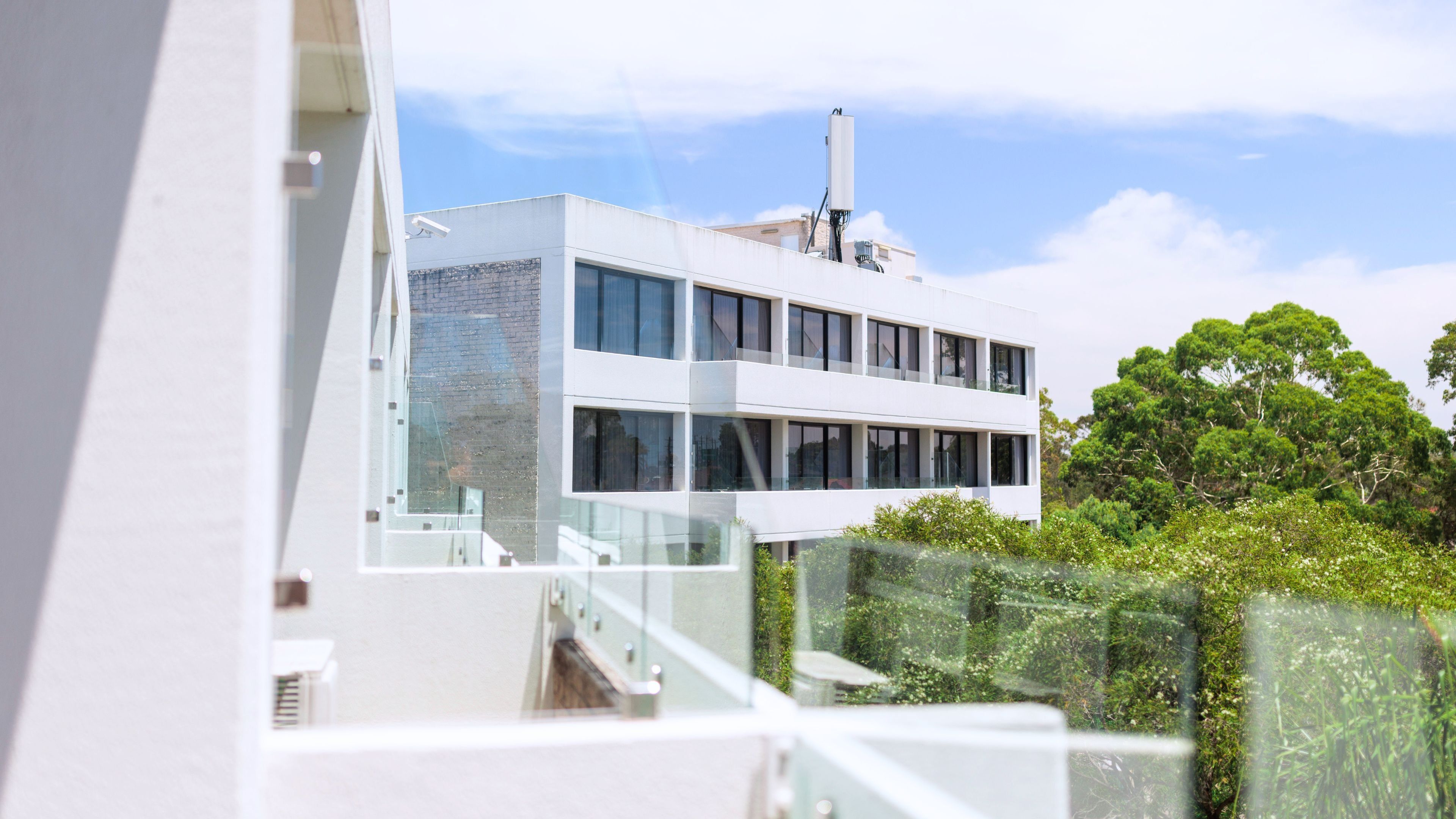 Een modern gebouw met een glazen gevel, een bakstenen muur en een witte buitenzijde.