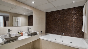 Features two large vessel sinks and a bathtub.