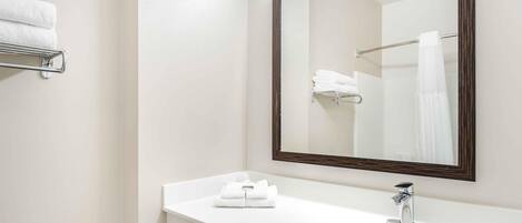 A bathroom with a white sink, a mirror, and a towel rack.