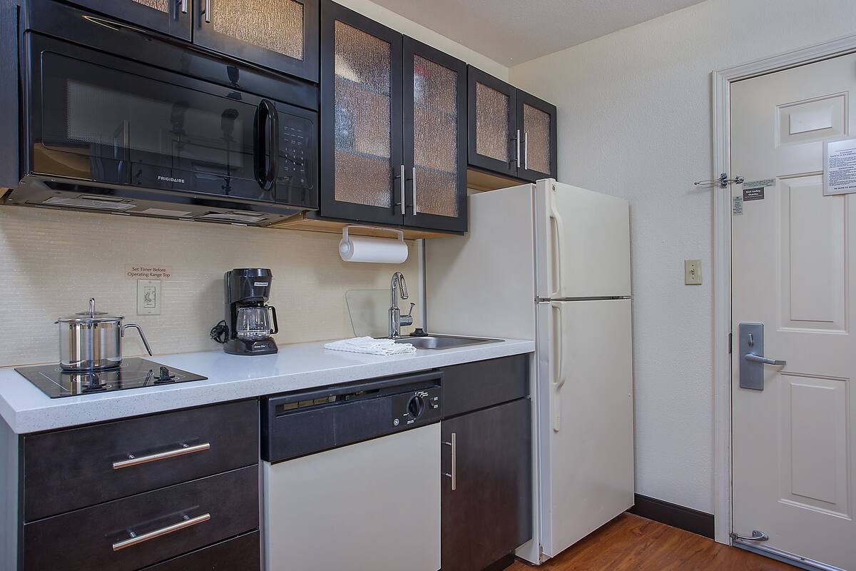 A compact kitchen with a microwave, coffee maker, and dishwasher.