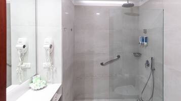 Ein modernes Badezimmer mit einer gläsernen Duschkabine, einem weißen Waschbecken und zwei an der Wand montierten Haartrocknern.
