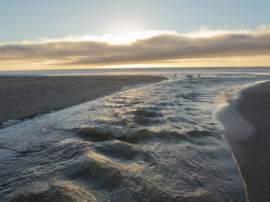 A beach with waves and a clear sky.