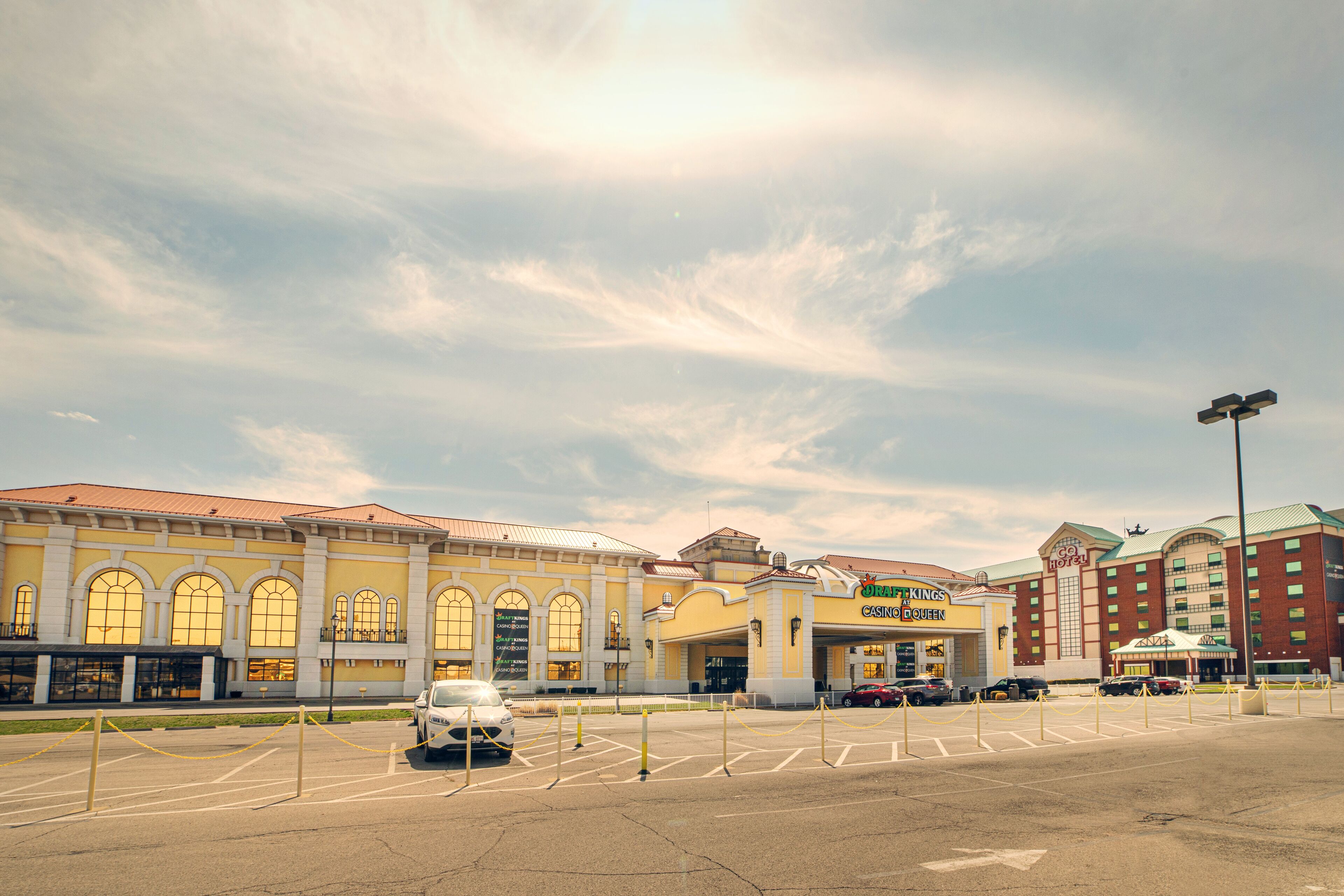 A hotel with a large parking lot, a casino, and a building with arched windows.