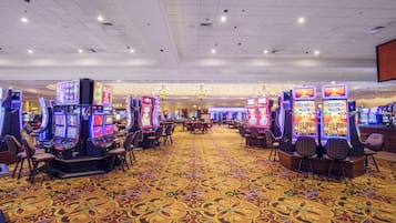 A casino with multiple slot machines and a patterned carpet.