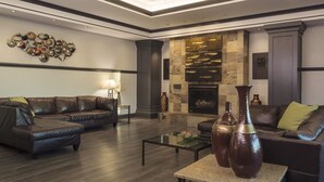 A modern living room with a sectional sofa, a coffee table, decorative vases, and a fireplace. - Casino Queen Hotel (East St. Louis)