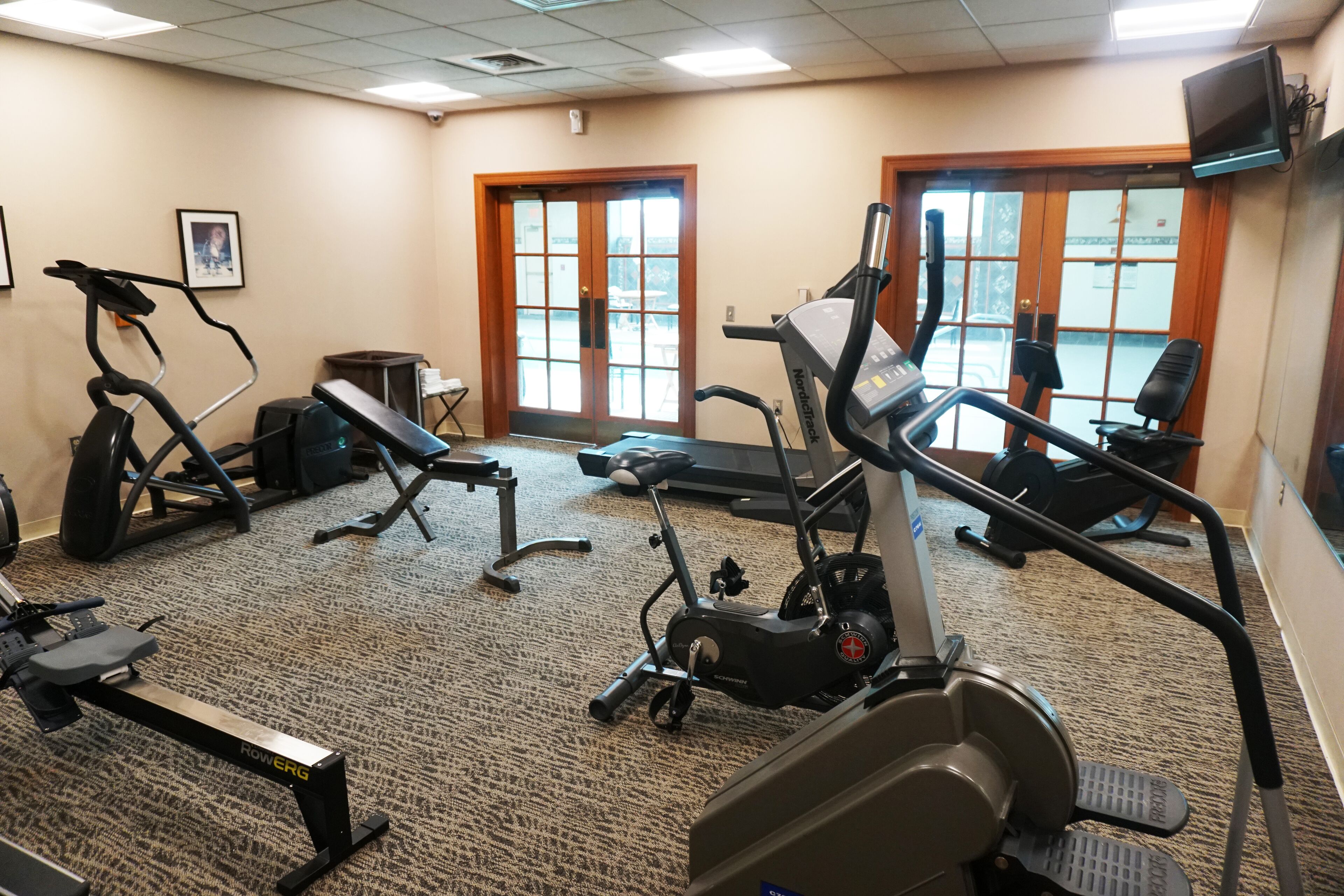 A gym with treadmills, a rowing machine, and a stationary bike.