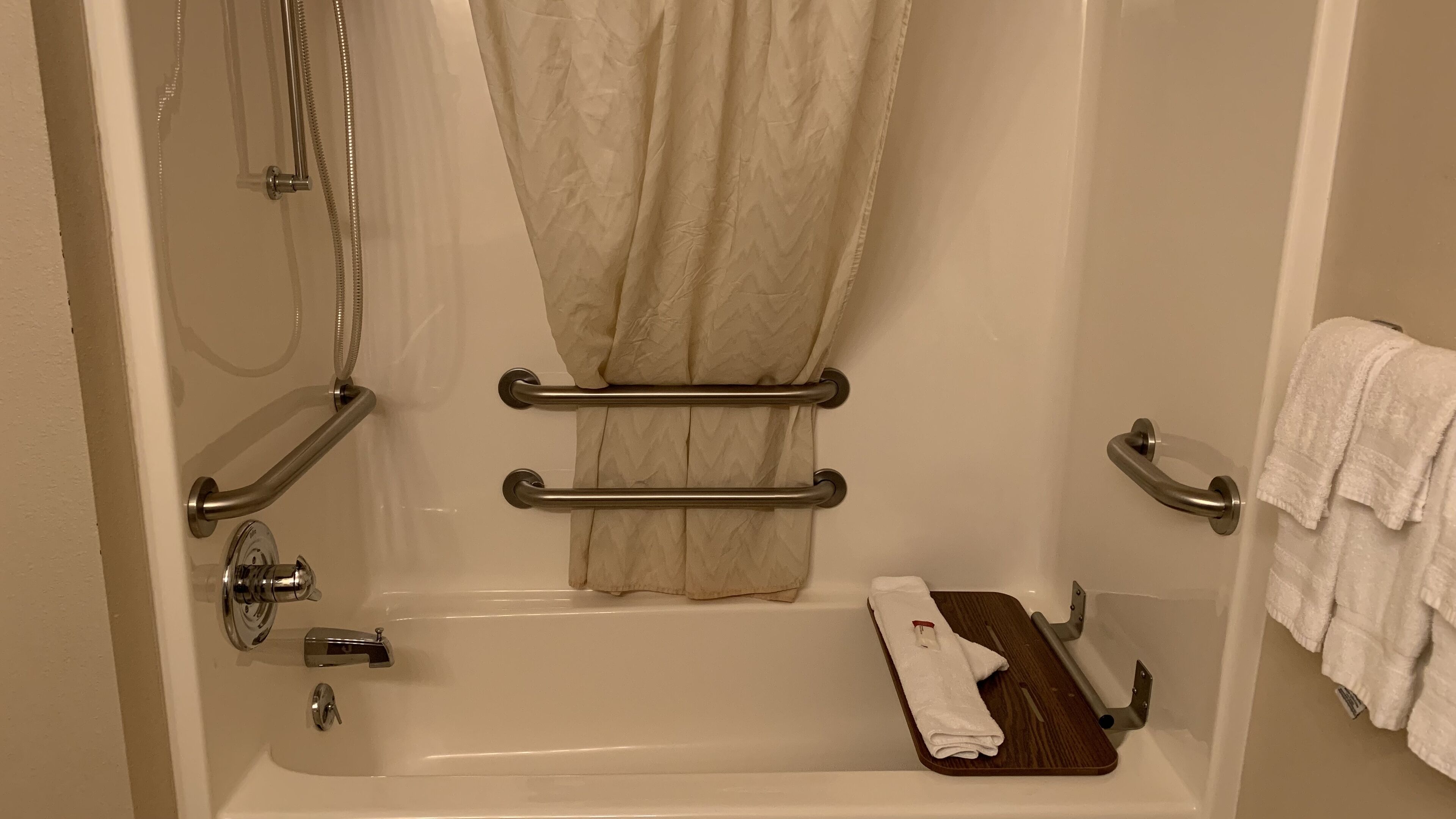 Ein Badezimmer mit Badewanne, Dusche und Handtuchhalter.