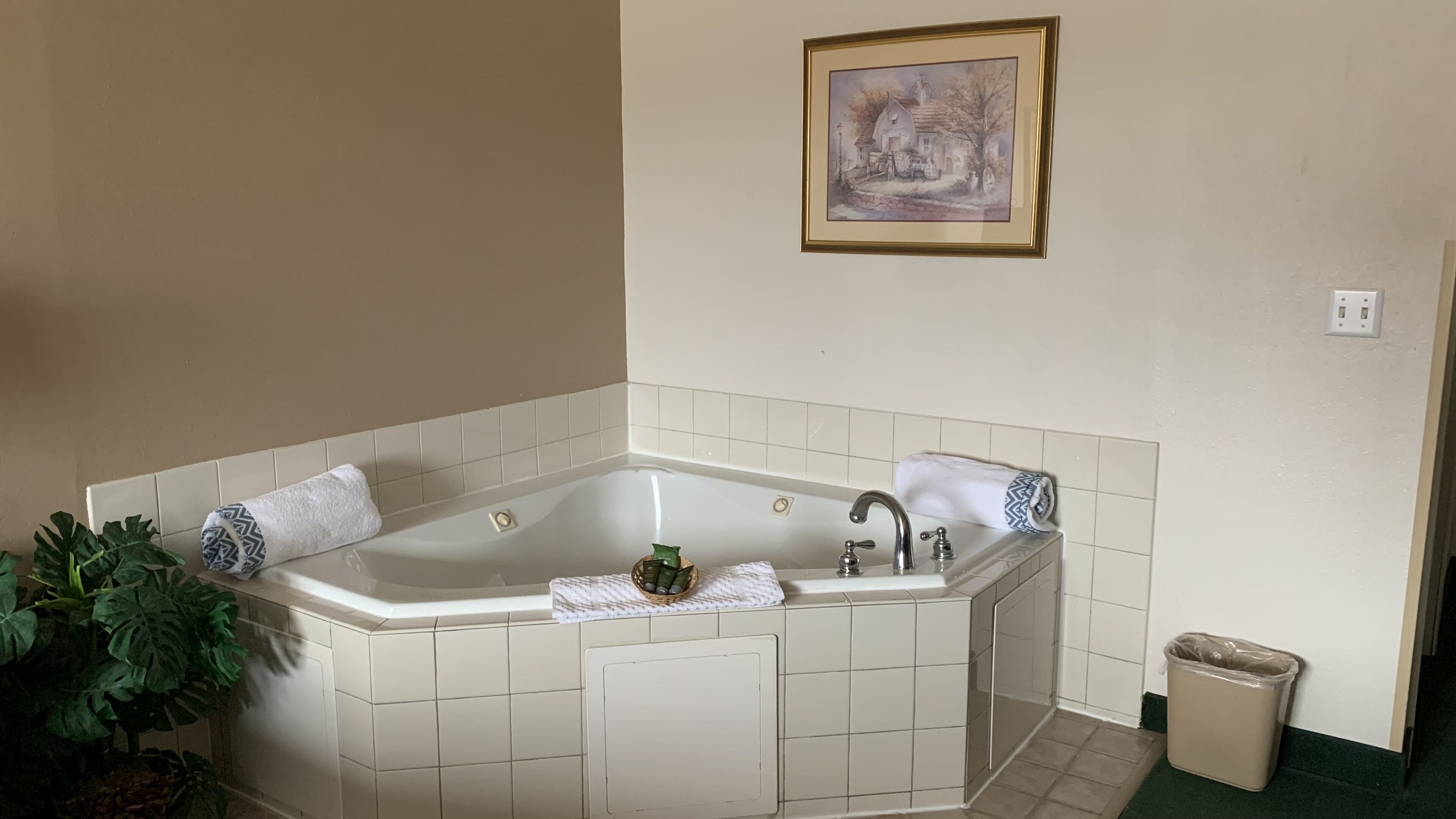 Un baño con una bañera independiente, un lavabo y un cuadro enmarcado en la pared.