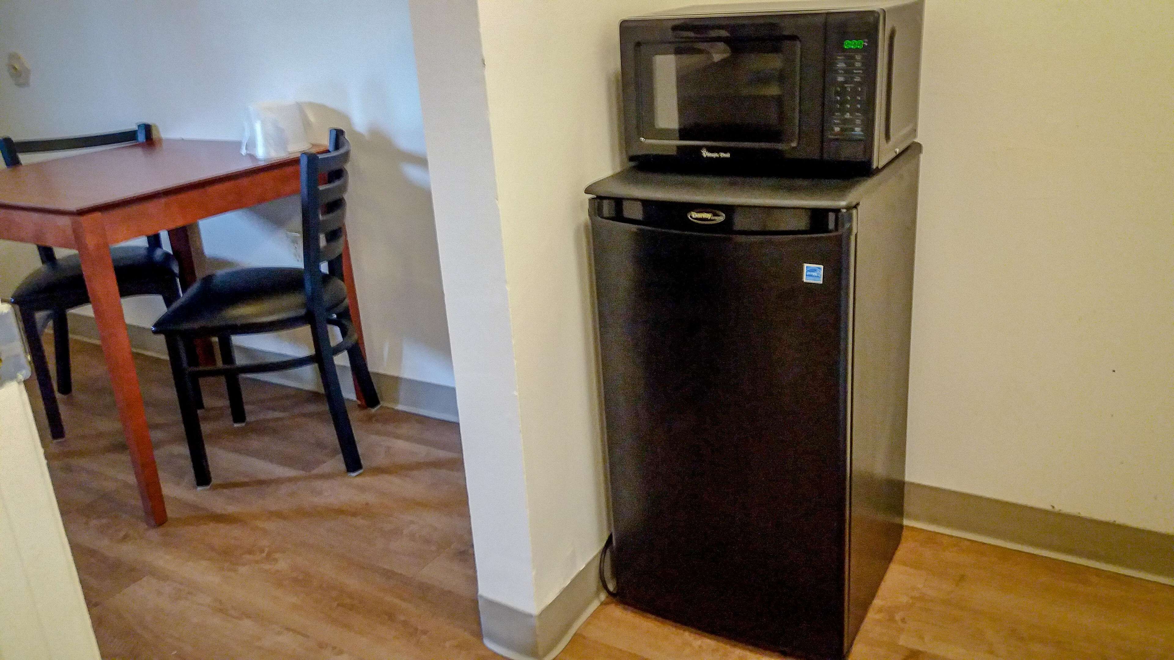 Una cocina compacta con un refrigerador y un microondas arriba.