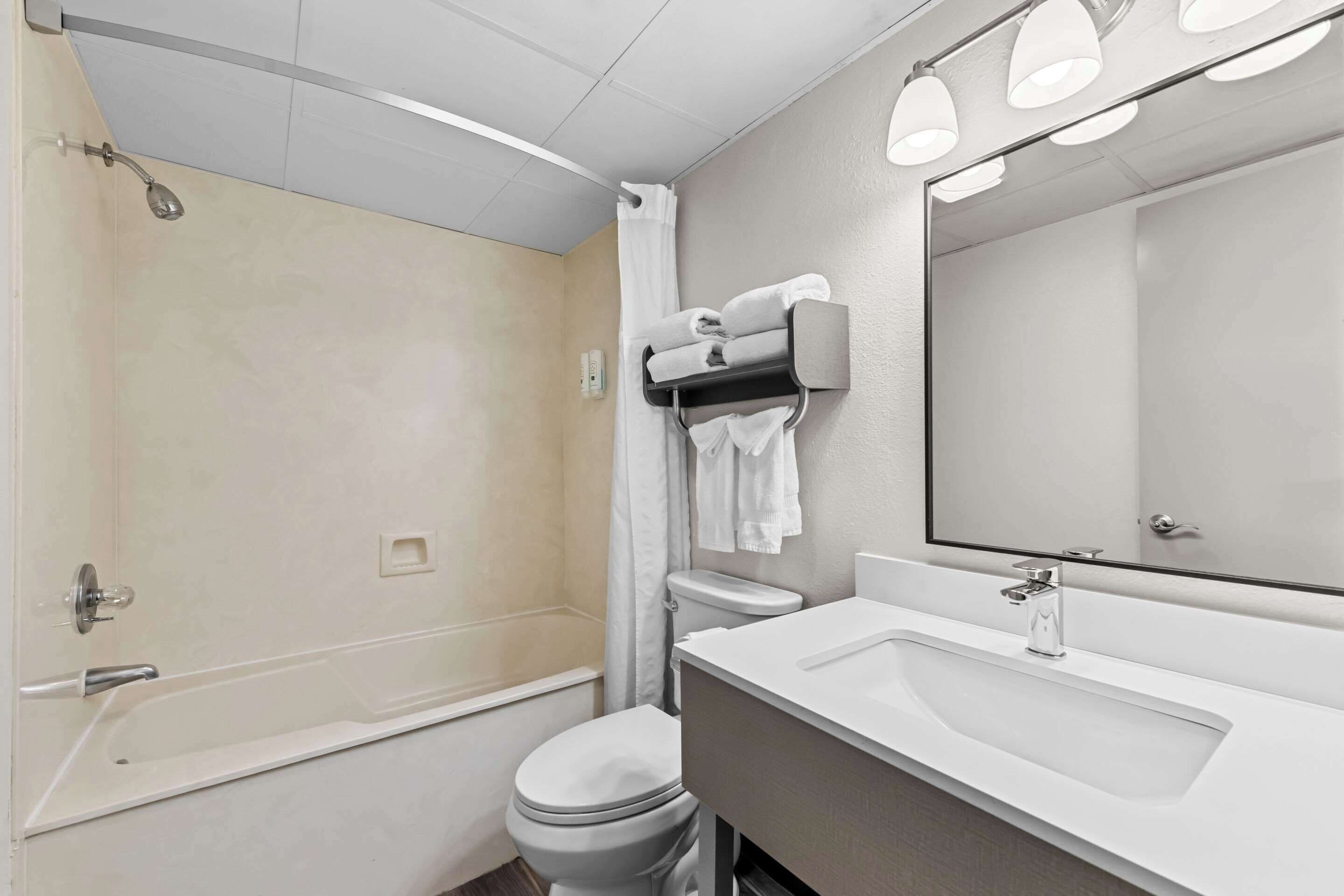 A modern bathroom with a bathtub, toilet, and sink.