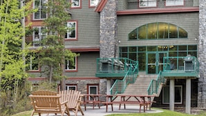 A building with a stone facade, green railings, and a staircase leading to an upper level. - WorldMark Canmore - Banff (Canmore)