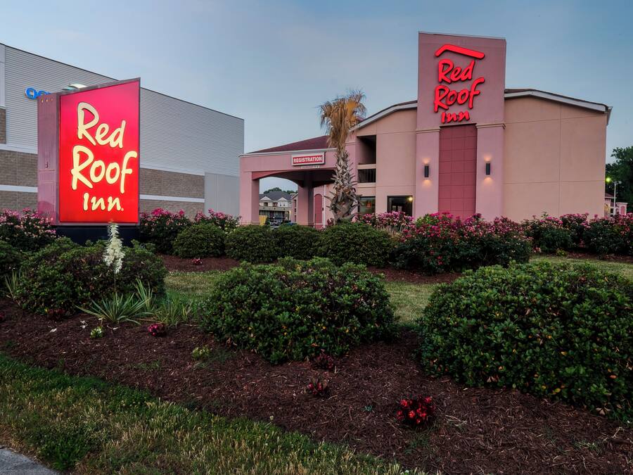 A Red Roof Inn with a registration arch and a large neon sign.