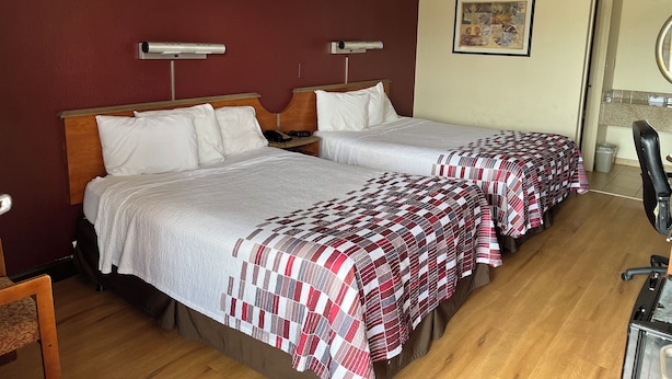 A hotel room with two beds, a wooden headboard, a small desk, and a chair. - Red Roof Inn Virginia Beach - Norfolk Airport (Virginia Beach)