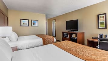 A hotel room with two beds, a television, a desk, and a microwave.