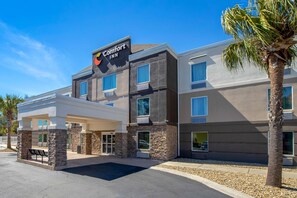 Un hôtel Comfort Inn au design moderne, doté d’une entrée couverte et d’un palmier à l’avant.
