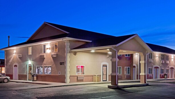Un motel su due piani con tetto piatto, diverse finestre e un ingresso ben visibile.
