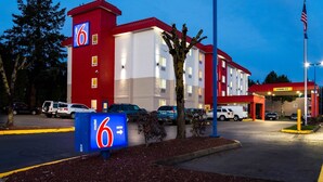 A motel with a red and white exterior, a '6' sign, and a clear entrance. - Motel 6 Wilsonville, OR - Portland (Wilsonville)