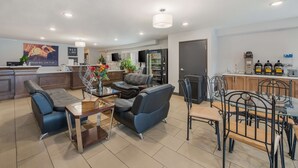 En moderne stue med et glasbord, to sofaer og et spiseområde med et bord af glas og metalstole.