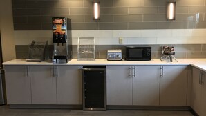 Una cocina moderna equipada con cafetera, tostadora, microondas y lavavajillas.