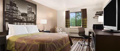 Una habitación de hotel con una cama grande, un escritorio con computadora, una silla, una ventana con cortinas y un cuadro de un paisaje urbano en la pared.