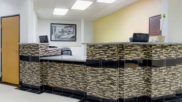 A reception area with a tiled counter, a framed picture on the wall, and a door to the left.