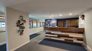 Un espace d’accueil avec un comptoir en bois, une carte du monde accrochée au mur et un élément décoratif mural.