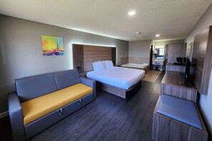Une chambre d’hôtel moderne, dotée d’un grand lit, d’un canapé, d’un bureau et d’une télévision.