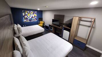 A hotel room with two beds, a TV, a desk, and a wardrobe.
