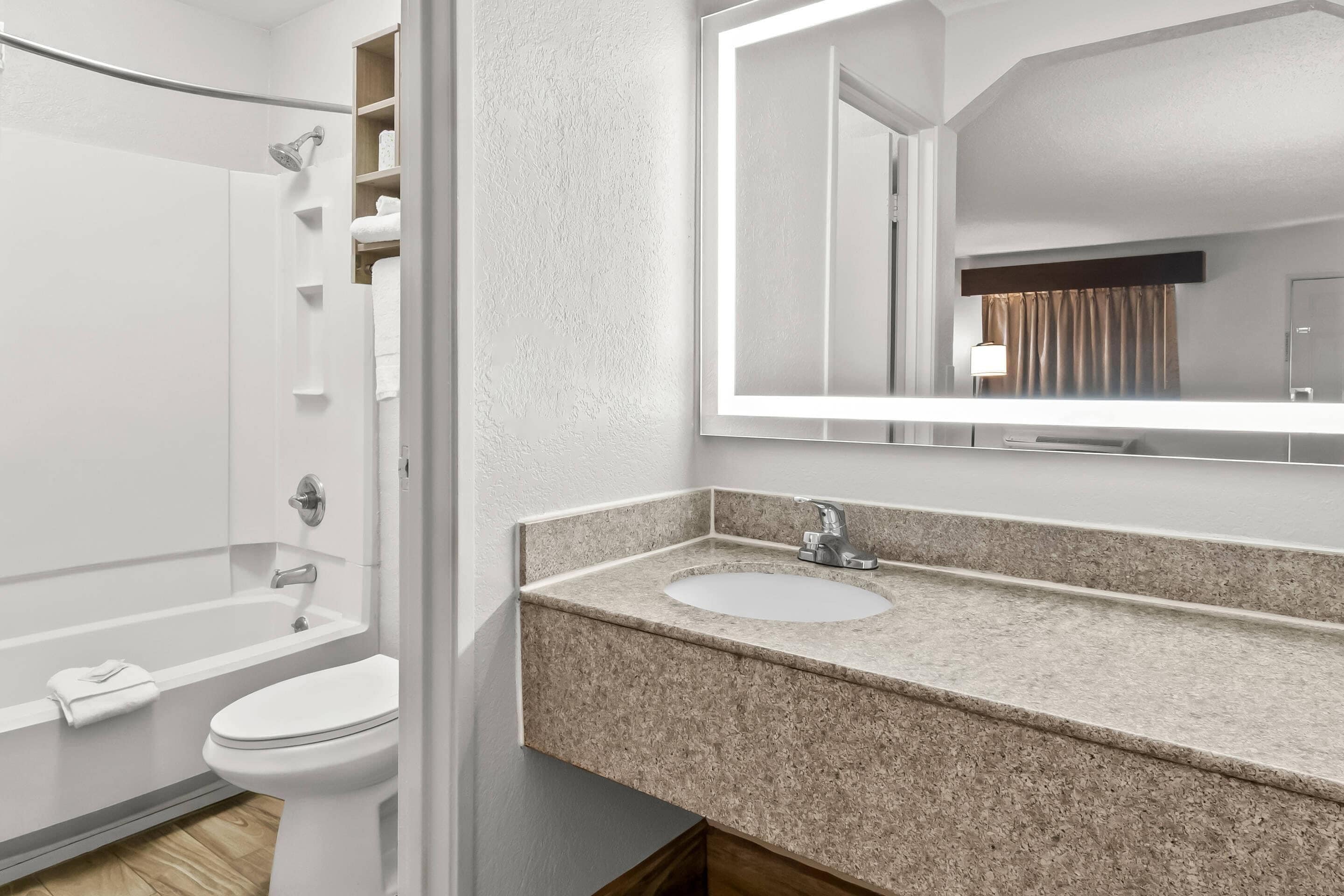 A modern bathroom with a shower, toilet, and sink.