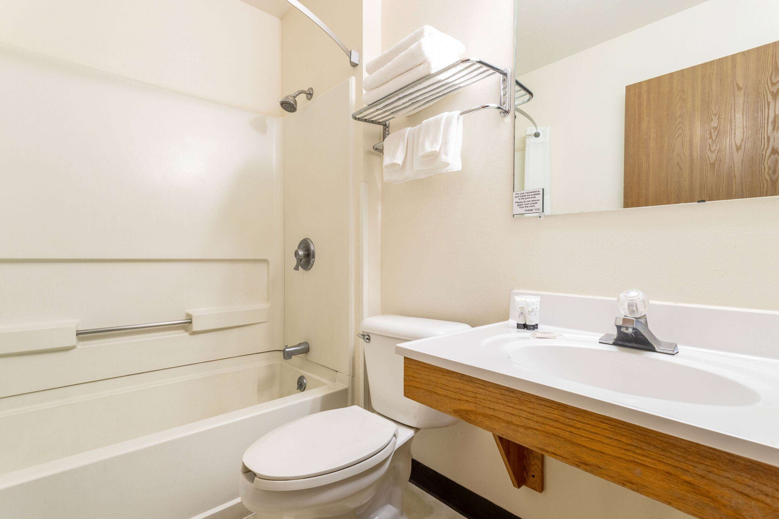 Un baño con bañera, inodoro y lavamanos.