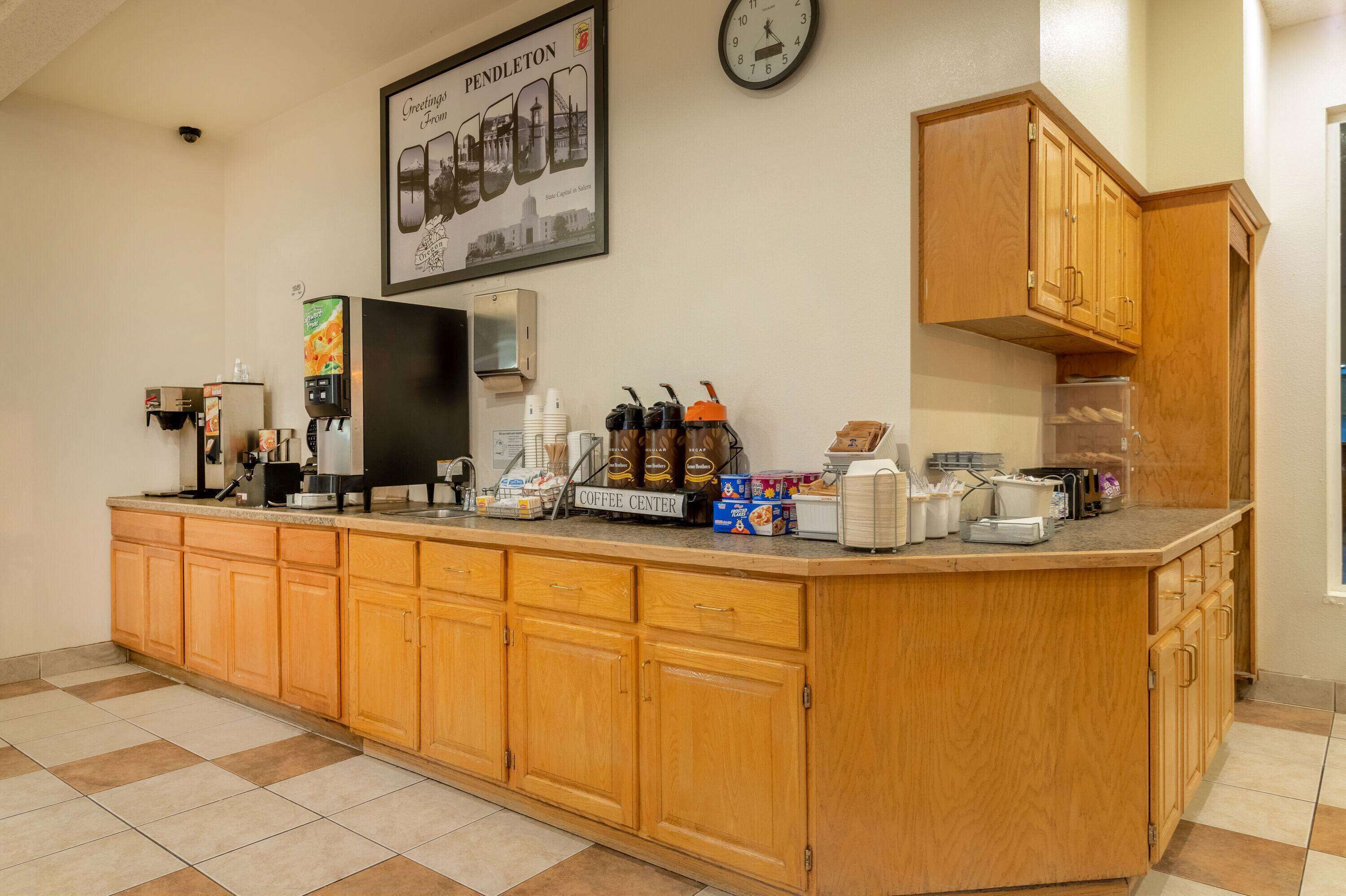A coffee center with a clock, a framed picture, and various coffee-making equipment.