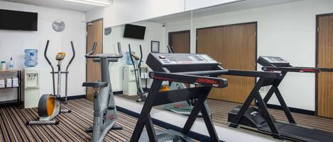 A gym with treadmills, an elliptical, and a water dispenser.