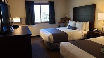 Ein Hotelzimmer mit Bett, Nachttisch, Lampe und Fernseher.