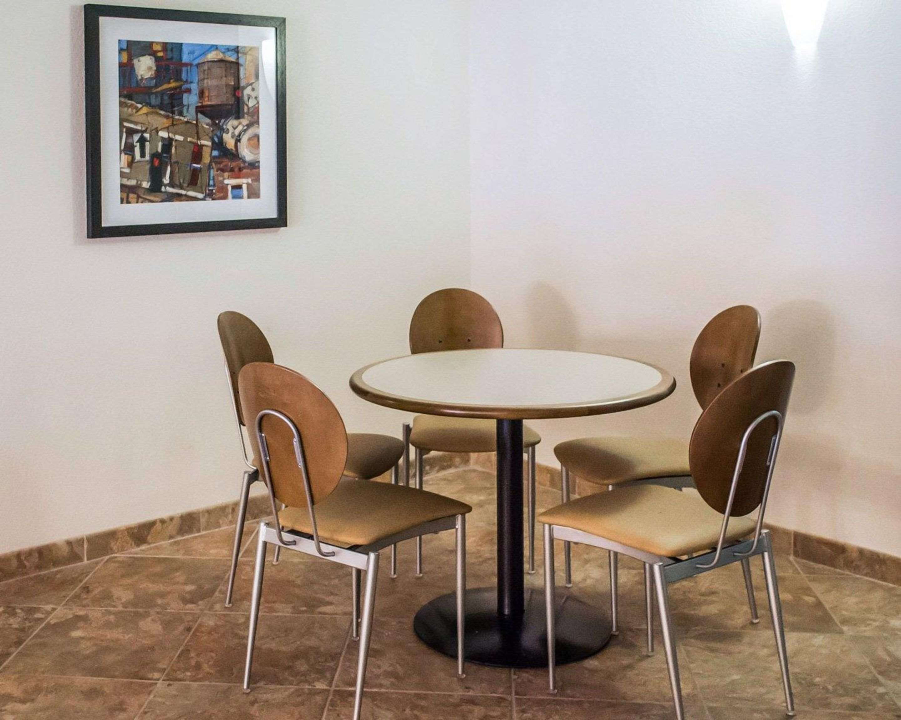 A dining area with a round table and six chairs.