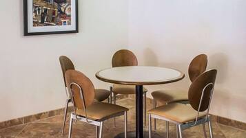 A dining area with a round table and six chairs.
