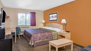 Habitación de hotel con cama, mesitas de noche, escritorio, silla, televisor y ventana con cortinas.