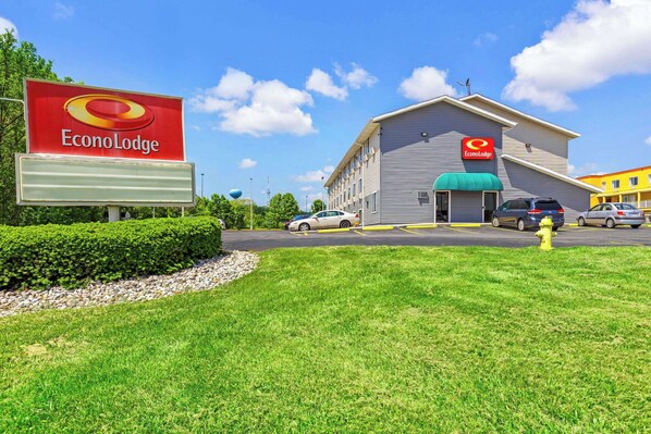 A hotel named EconoLodge with a large sign, a parking lot, and a grassy area in front.