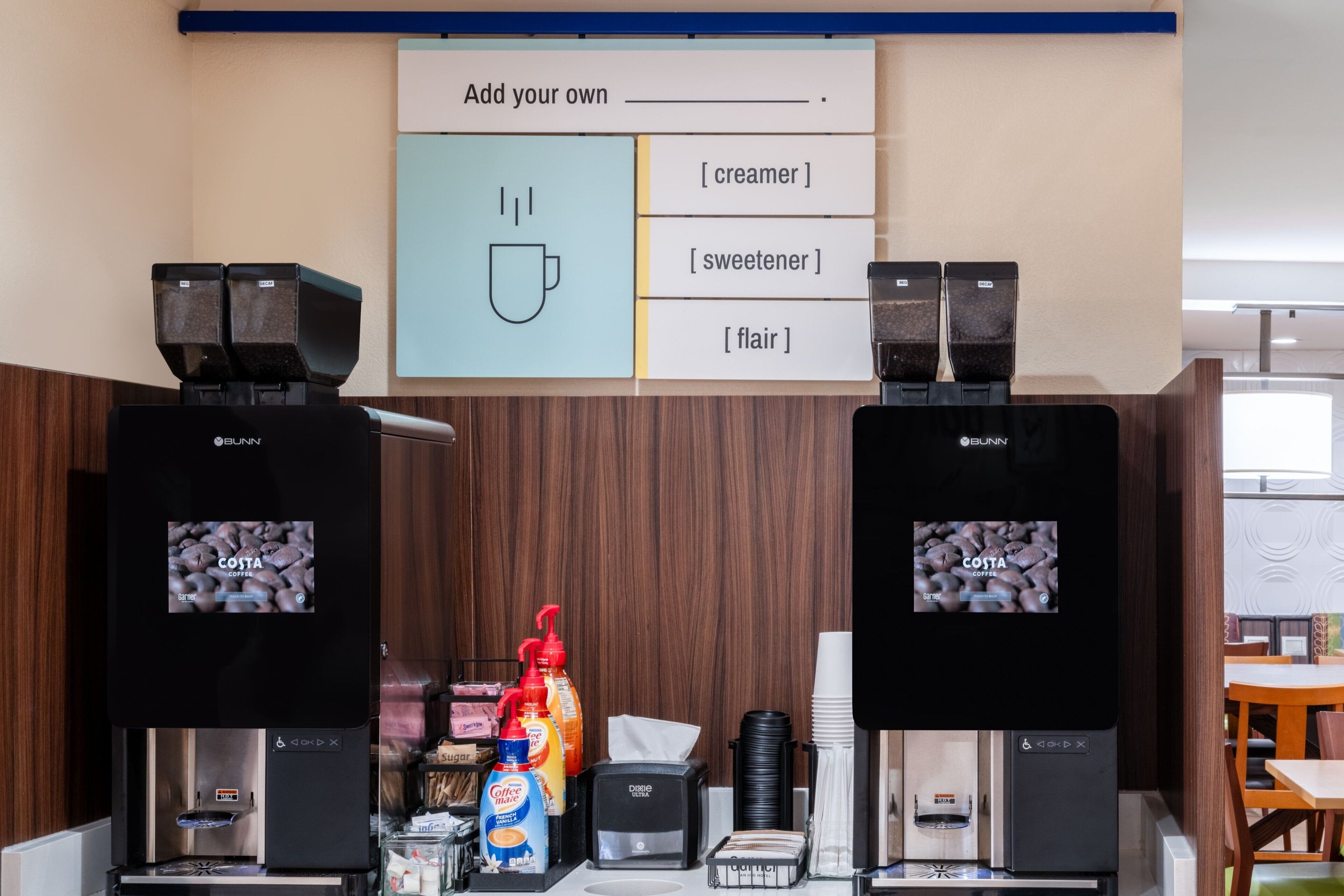 A coffee station with two coffee machines, a menu board, and various coffee-related items.