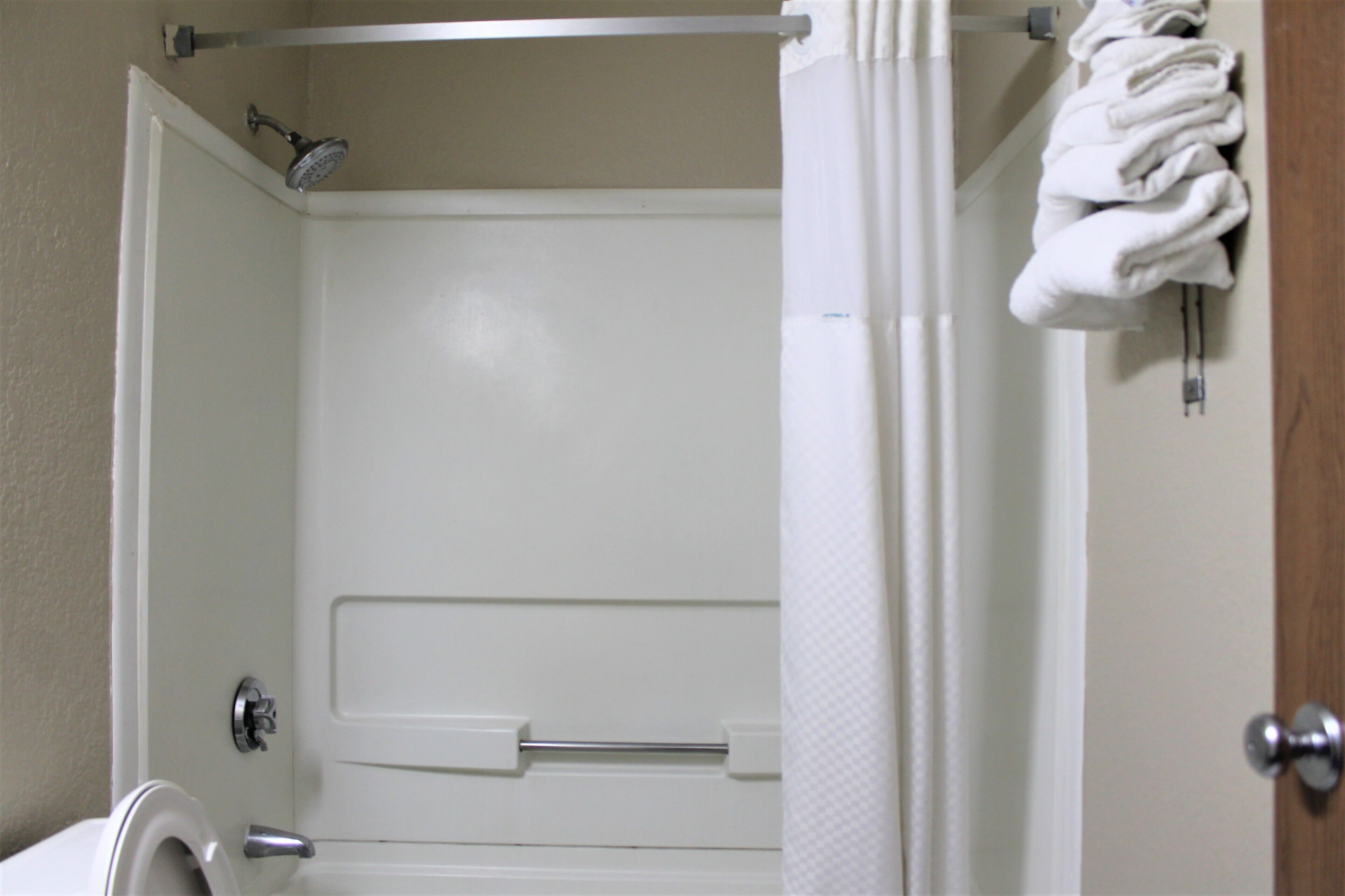 A bathroom with a shower, toilet, and towel rack.