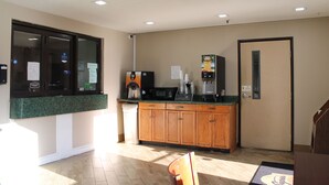 Una cocina con armarios de madera, cafetera, microondas y refrigerador.