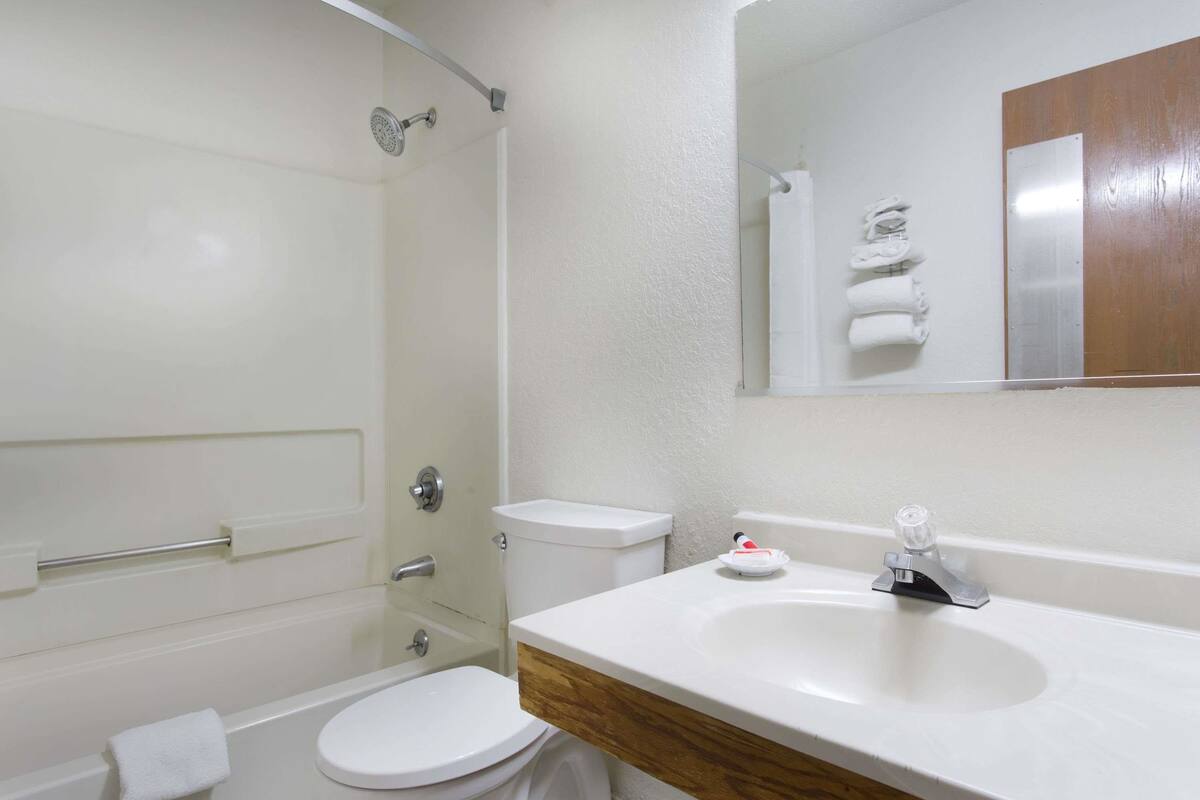 Une salle de bain avec des toilettes, un lavabo et une douche.