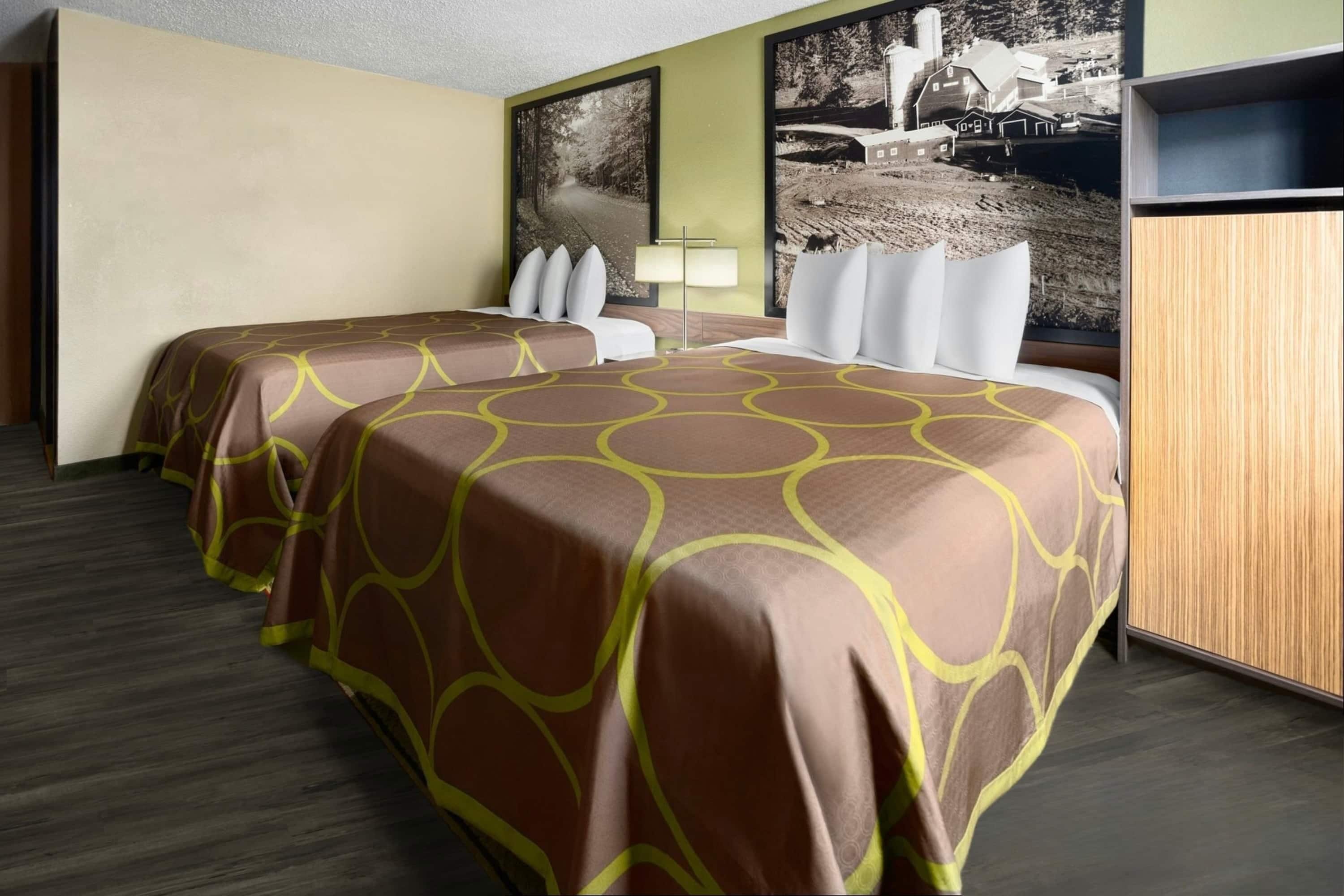 Une chambre d’hôtel avec deux lits, un bureau et une chaise.