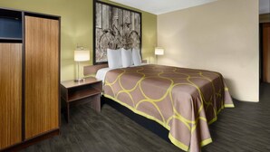 A hotel room with a bed, a wooden wardrobe, a nightstand, a lamp, and a wall art piece. - Super 8 by Wyndham St. Clairsville OH/Wheeling WV Area (St. Clairsville)