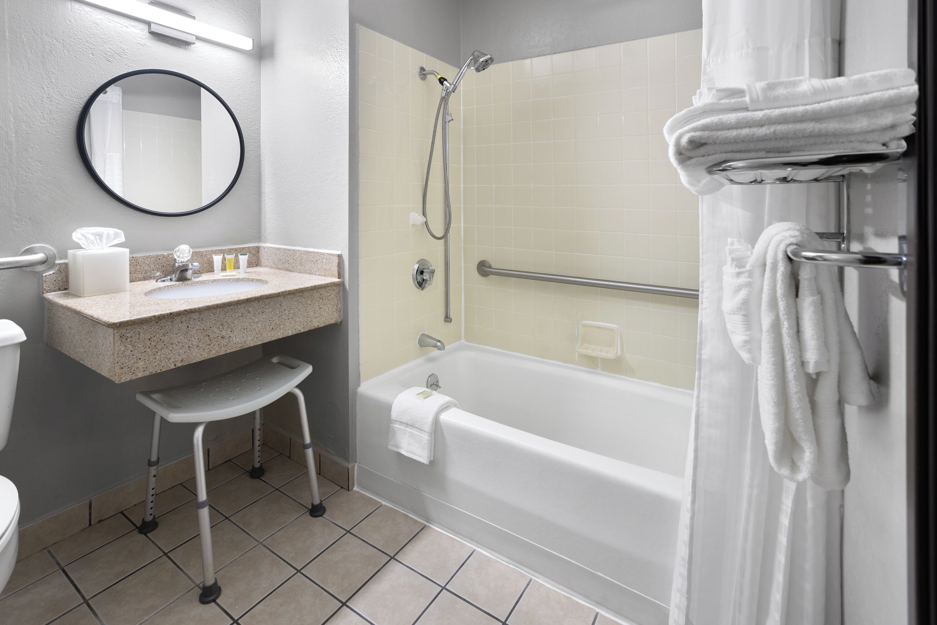 Un baño con lavamanos, espejo, inodoro y bañera.