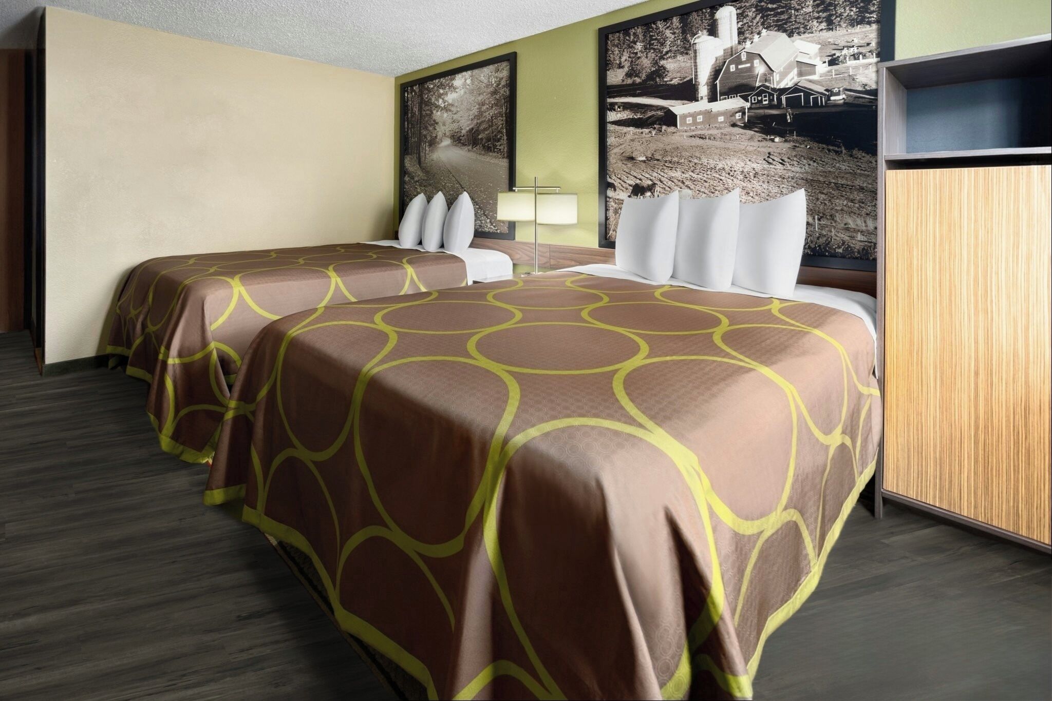 A hotel room with two beds, a desk, and a wardrobe.
