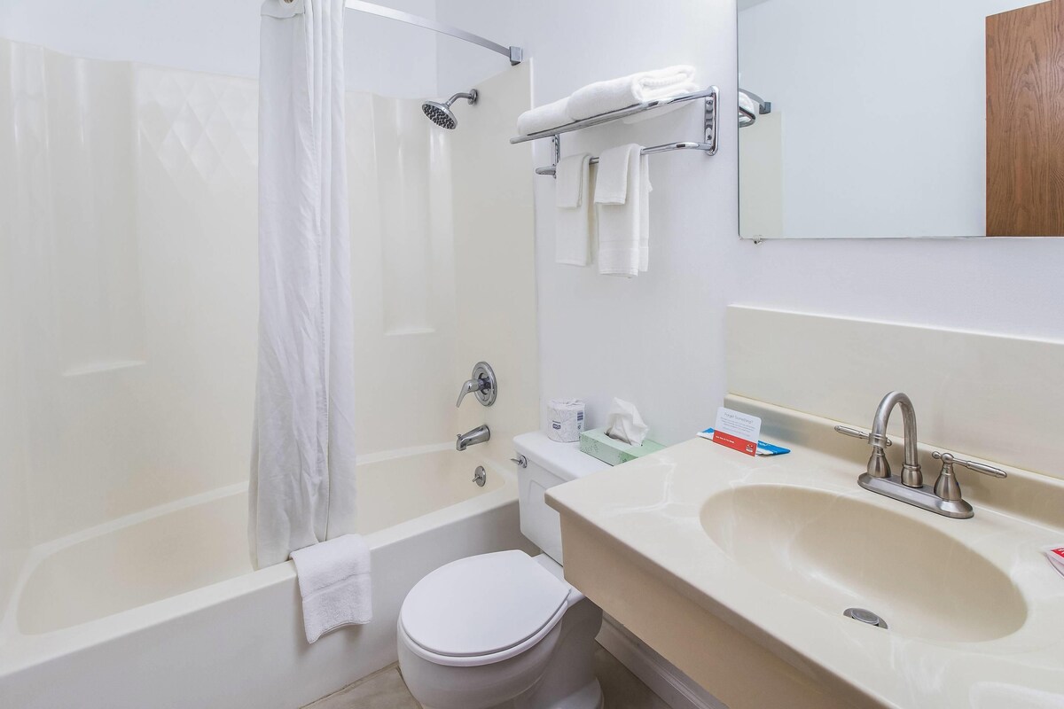 Un baño con bañera, inodoro, lavabo y espejo.